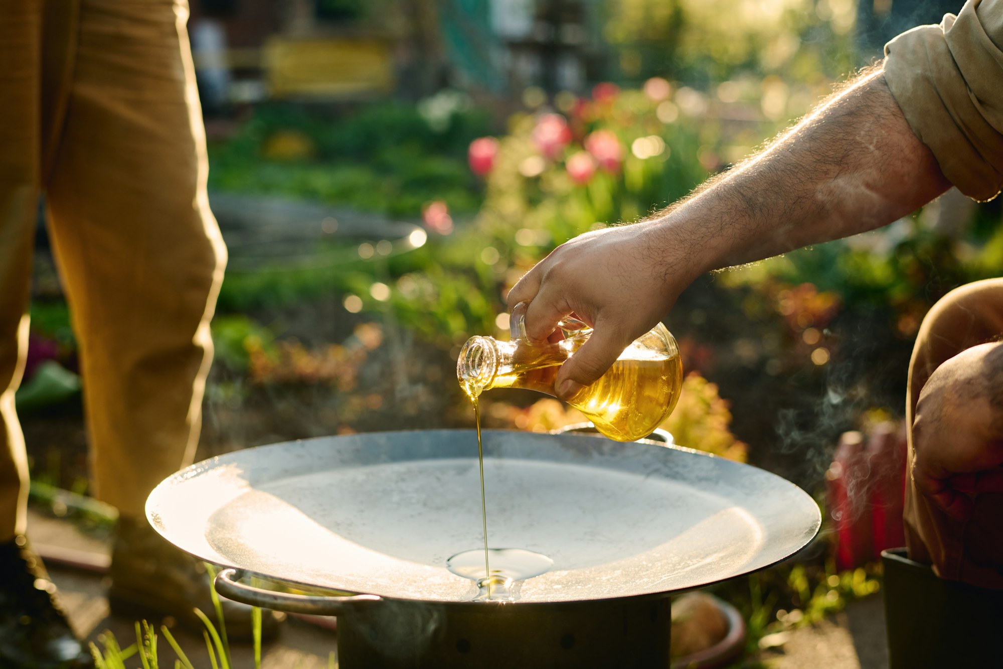 Man pouring olive oil on frying pan