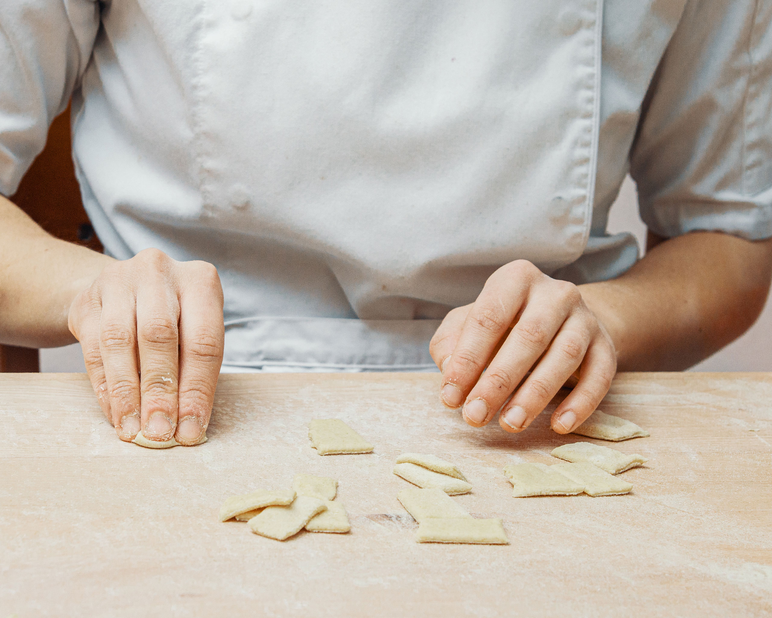 Cuoca professionista del Ristorante Costa di Cinisello Balsamo (Milano) prepara la pasta fresca tagliando pezzi di impasto su un tavolo infarinato in cucina